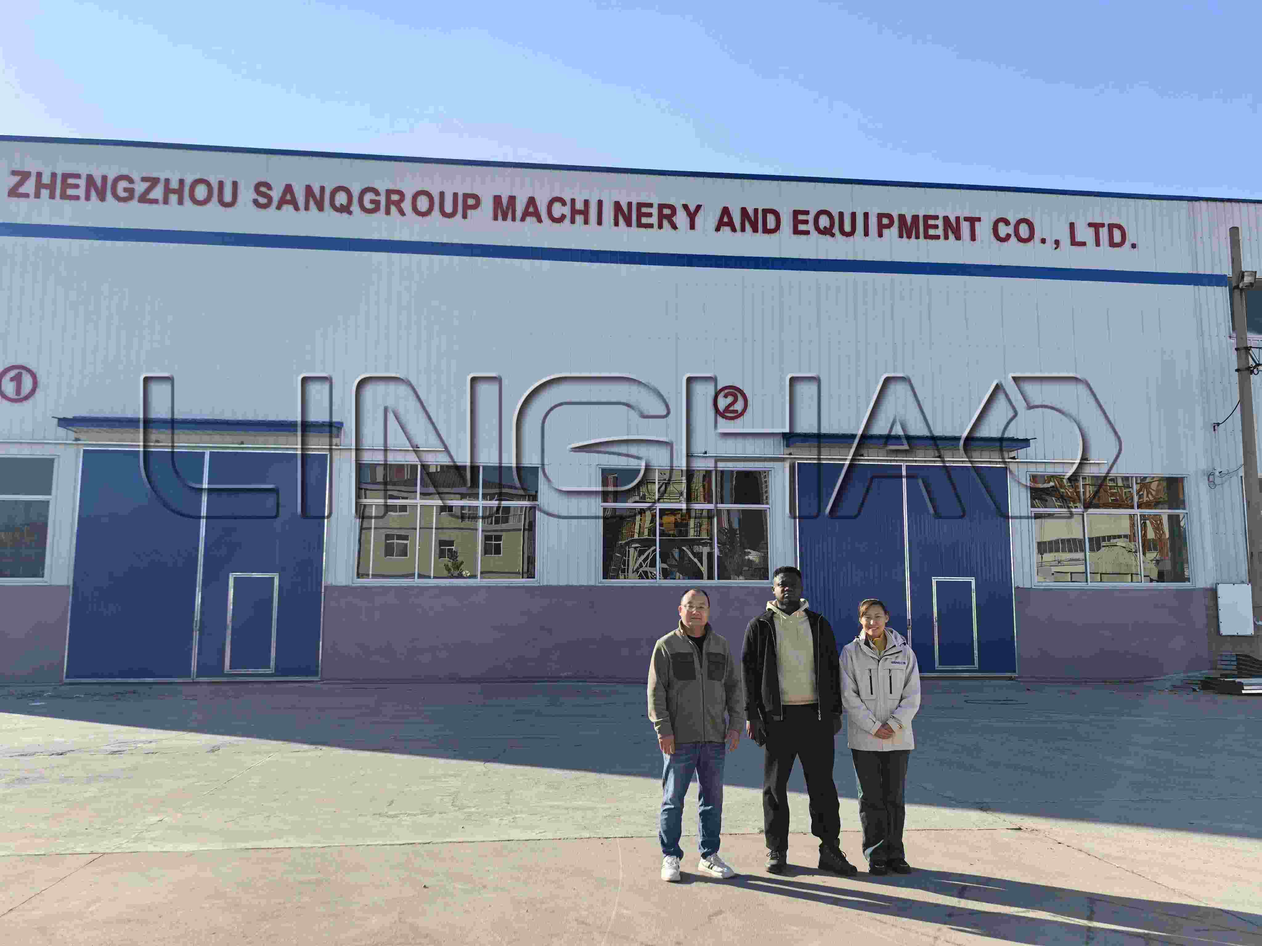 Client observing skilled workers assembling trailer pump hydraulic systems with precision tools